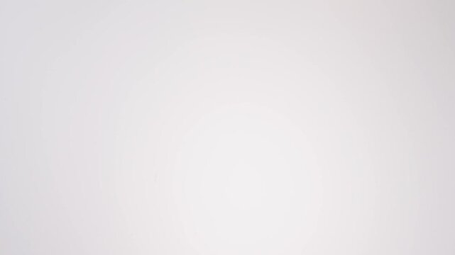 Shower of chewy golden bagels falling on bright white studio backdrop in slow motion. office breakfast reels, weekend brunch videos, jewish bakery content.