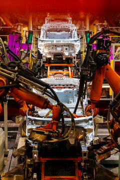 Robotic arms are welding body weld points on an automated production line at an automobile factory.