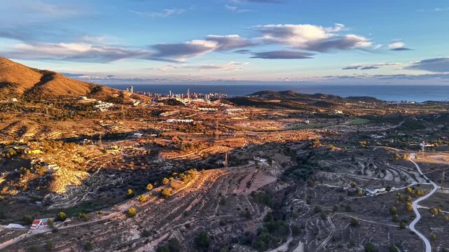 Golden hour terraces winding roads to coast, aerial view highlighting switchbacks and scenic curves, ideal