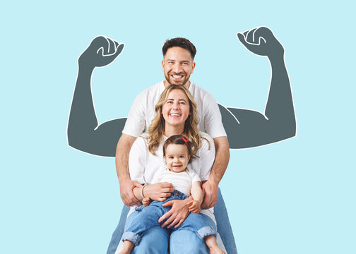 A cheerful young family with a happy baby showing strength. A symbolic image of a classic family overcoming difficulties.