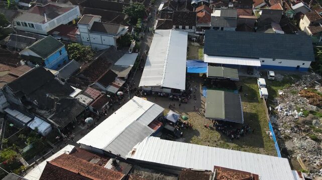 Aerial footage of crowds of people and cultural processions or Javanese traditional festivals, amidst the density of urban villages.