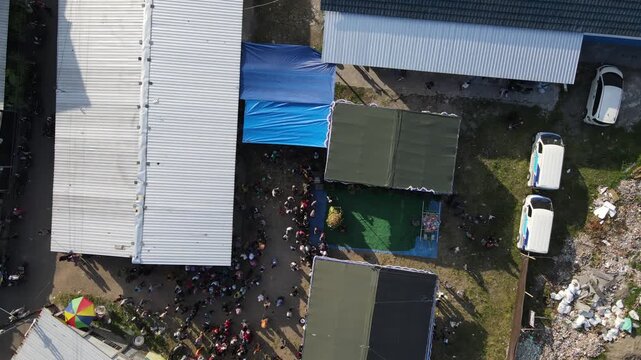 Aerial footage of crowds of people and cultural processions or Javanese traditional festivals, amidst the density of urban villages.