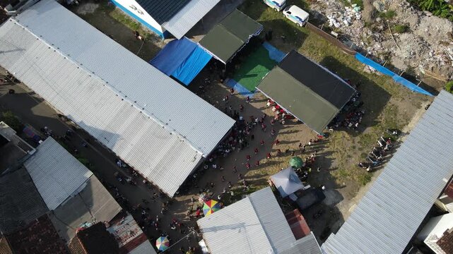Aerial footage of a cultural procession or Javanese traditional festival, amidst the density of urban villages.