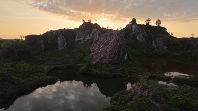 Drone footage of rock cliffs and ponds at Frog Hill Kubang Semang during sunrise.