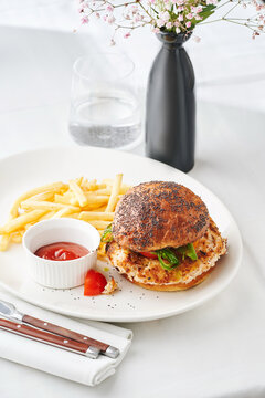 Chicken sandwich with poppy seed bun, side of fries and ketchup for casual dining menu or food delivery concept