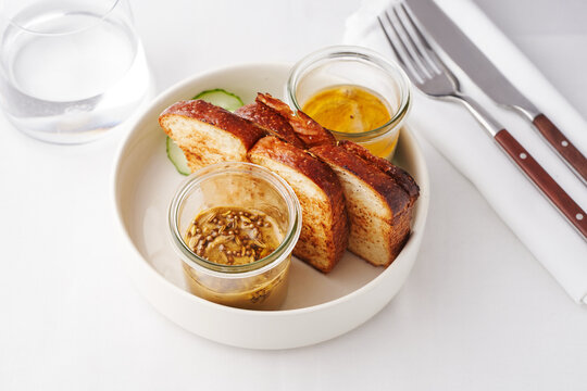 Homemade bread served with pickled cucumber and artisanal dips ideal for sharing in a casual dining setting