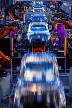 Robotic arms are welding body weld points on an automated production line at an automobile factory.
