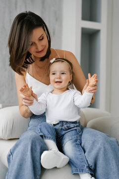 Smiling Child Sitting on Mother Lap Playing