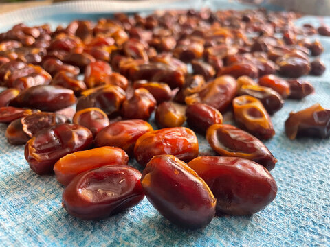 Photo of fresh dates scattered on a flat surface. The perfect ingredient for your culinary projects. The image is perfect for packaging design, healthy lifestyle websites, social media posts, and prom