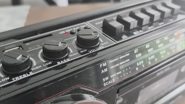 Testing an old tape recorder by inserting a cassette and pressing the play button to check if it works