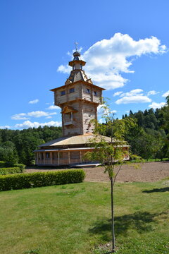Wooden tower in a park surrounded by trees and greenery on a sunny day in summer