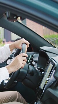 Handsome smiling man sitting inside a modern car, setting a navigation route while looking at the camera. Concept of travel planning, navigation technology, road trip, transportation, mobility, GPS