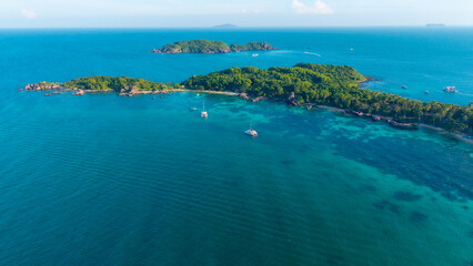 Obraz premium Aerial view of beautiful landscape, tourism boats, and people swimming on the sea and beach on Gam Ghi island in Phu Quoc, Kien Giang province, Vietnam