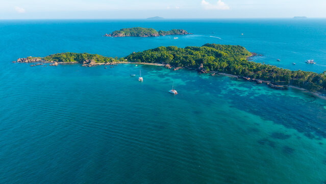 Aerial view of beautiful landscape, tourism boats, and people swimming on the sea and beach on Gam Ghi island in Phu Quoc, Kien Giang province, Vietnam