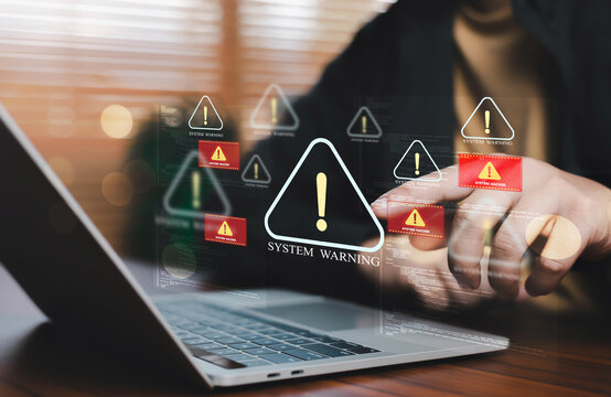 IT professional responding to critical system warning alerts on a laptop, illustrating cyber incident response, infrastructure monitoring, network defense, security operations, threat detection