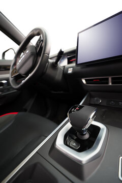 Close up of a modern automatic gear shifter inside a luxury car cockpit with selective focus