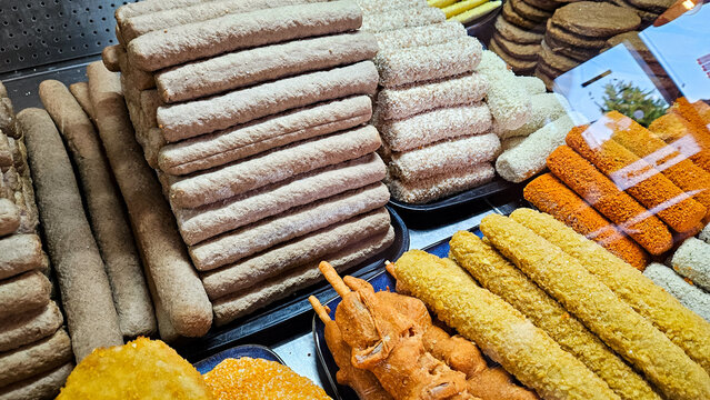 Frozen frying snack bar snacks in fitrine of store counter in Netherlands with classics as the frikadel, kroket, kipcorn and kaassouffl&eacute;. Dutch friday night treats. Landscape photo with window reflect