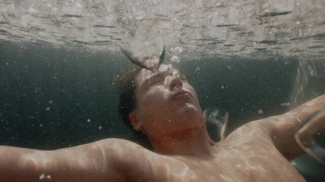 Underwater calm cold plunge as man recovers in an outdoor ice bath