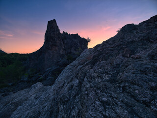 Obraz premium Limestone mountains at dawn, featuring a sharp and unique landscape with sparse vegetation set against a backdrop of sky and clouds in Surat Thani Province, Thailand.
