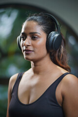  Maharashtra, Sion, India- 22nd March 2026- Young Indian girl  in her active wear  listening to music  in gym. © Pure Passion Product