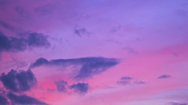 Morning or evening sky. Colorful clouds fill twilight with gradients of purple and pink during sunset or sunrise. Natural background. Beauty in nature. Expressive cloudscape. High quality 4K footage.