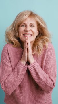 Expressive mature woman feeling shocked and surprised, holding her hands to her face in amazement. Portrait of a beautiful lady in disbelief