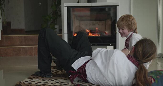 Man and Kid Boy Have Fun Playing Together on Floor Near Fireplace. 4K 10-bit