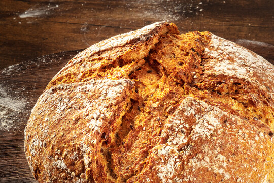 Homemade artisan sourdough bread loaf on a rustic wooden cutting board