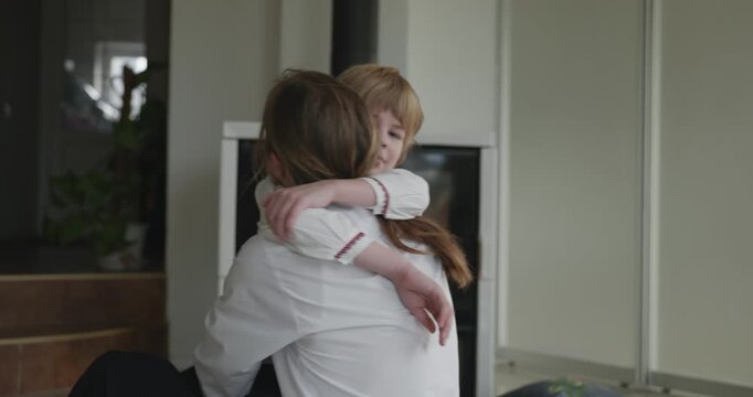 Man Hugs Embraces Kid Boy Have Fun Together on Floor Near Fireplace. Happy Family in Ukrainian Traditional Attire. 4K 10-bit