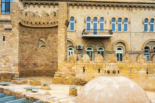 Medieval fortress walls and tower of Icheri Sheher with the dome of Yeraltı Hamam in the foreground, Baku, Azerbaijan.