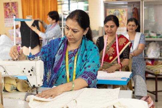 Indian Woman Garment Workers Operating Industrial Sewing Machines in an Export House Textile Factory Women textile using sewing machine or textile production line in vocational training center