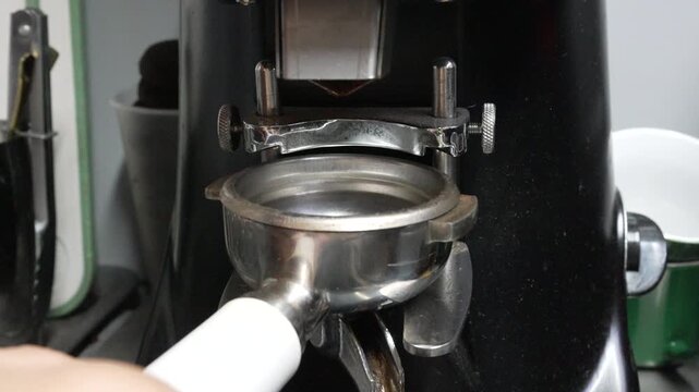 Coffee grinding beans, fresh espresso being prepared in portafilter at cafe, cinematic shot of professional equipment in modern kitchen preparing morning brew