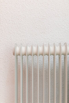 Home radiator in front of textured wallpaper interior wall