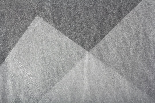 sheets of thin translucent tissue paper on a black background