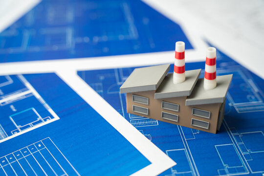 Industrial plant on blue drawings. Development and construction of enterprises and industrial infrastructure. Economic development, high technology.