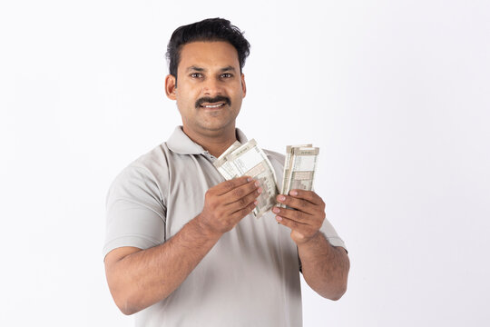 Portrait of a Indian young man showing counting indian rupees on white background.