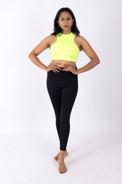 Indian Young slim woman in white sportwear on white background. Slim fit female with flat belly. Body care, healthy and sporty life