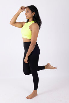 Indian Young slim woman in white sportwear on white background. Slim fit female with flat belly. Body care, healthy and sporty life
