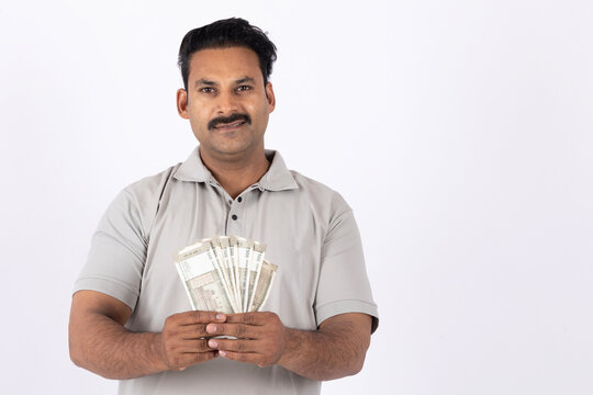 Indian young man showing currency or indian rupees on white background.