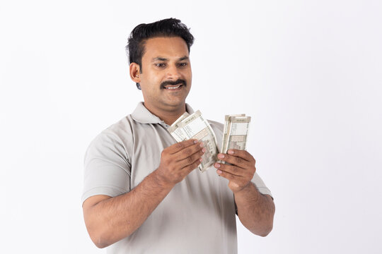 Portrait of a Indian young man showing counting indian rupees on white background.