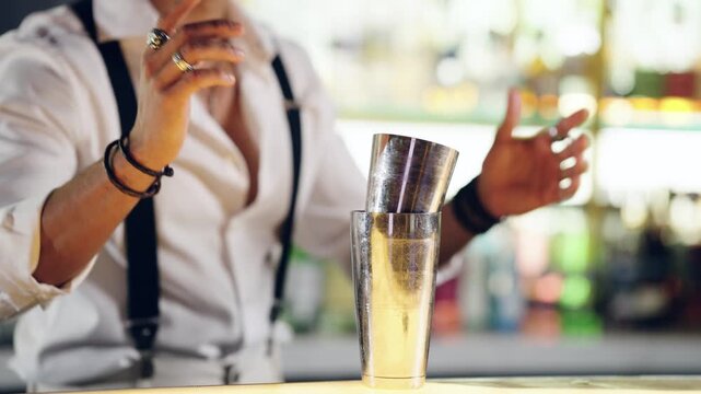 Talented barman expertly shaking a cocktail in a modern bar. Professional mixologist crafting a drink with skill and flair behind the counter