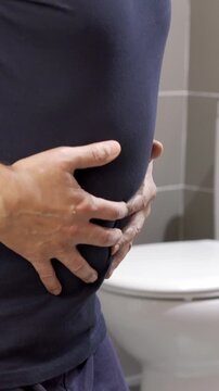 Constipation and diarrhea in bathroom. Hurt man touch belly stomach ache painful.Colon inflammation problem, toxic food, abdominal pain, abdomen, constipated in toilet, stomachache, Hygiene