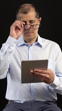 Tablet, filming and man on set with lights reading for documentary interview or podcast episode. Digital technology, research and male journalist recording for online live streaming show with script.