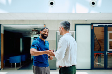 Diverse businessmen shaking hands after a successful meeting establishing a new partnership and collaboration in a corporate office © we.bond.creations