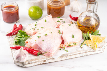Fresh raw organic chicken thighs, with spices and condiments