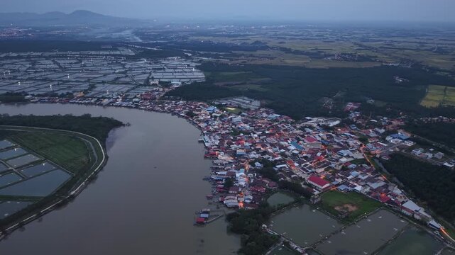 Aerial night view of Sungai Udang village along the river with surrounding fish farms.