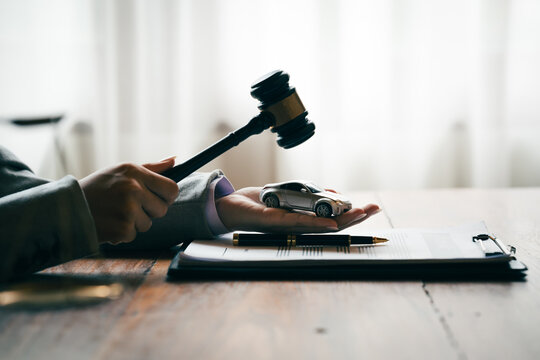 Judge's gavel above a model car, symbolizing vehicle auctions, legal disputes, insurance claims, and automotive law.