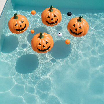 floating jack-o'-lanterns in a sunny pool during halloween providing a whimsical festive atmosphere