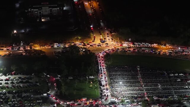 Night aerial shot of crowded parking and traffic at Batu Kawan Modifighter automotive festival at Batu Kawan Stadium