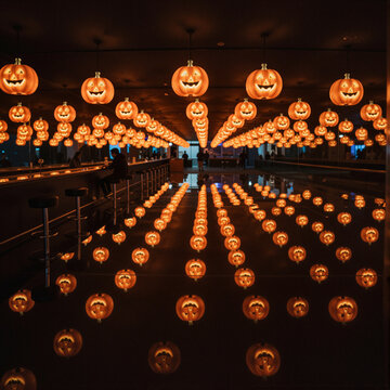 halloween themed bar with illuminated pumpkin lanterns reflecting on surface creating spooky ambiance